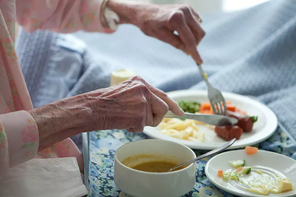 Seniorin genießt ein gesundes, ausgewogenes Mittagessen im Bett
