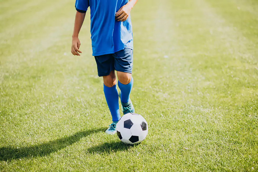 Junge beim Fußballspiel sportlicher Junge beim Fußballspiel, der danach durch Alpha Cooling regeneriert